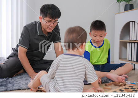 Father and Sons Spending Quality Time Together at Home, Playing and Bonding in a Cozy Living Room Setting 121346438