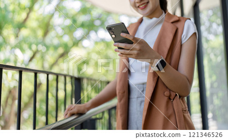 Confident Businesswoman Analyzing Stock Market Trends on Smartphone in Modern Office Setting Confident Businesswoman Analyzing Stock Market Trends on Smartphone in Modern Office Setting 121346526