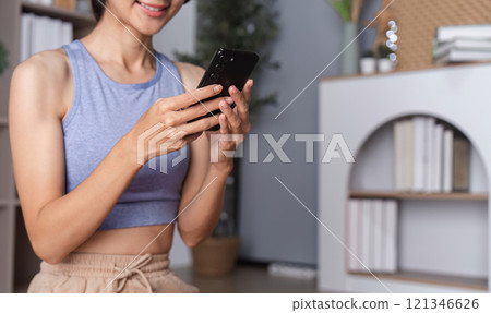Young Healthy Woman Relaxing at Home After Yoga Session, Embracing Wellness and Tranquility in a Modern Living Space 121346626