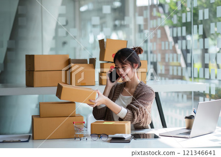 Young Woman Selling Products Online from Home Office with Laptop and Packages, E-commerce Business Concept Young Woman Selling Products Online from Home Office with Laptop and Packages, E-commerce Business Concept 121346641