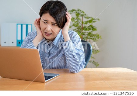 A woman troubled watching a personal computer 121347530