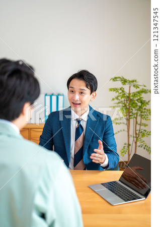 A businessman giving an explanation on a PC A businessman giving an explanation on a PC 121347545