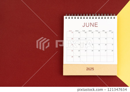 June 2025 blank desk calendar on red and yellow color background. 121347634