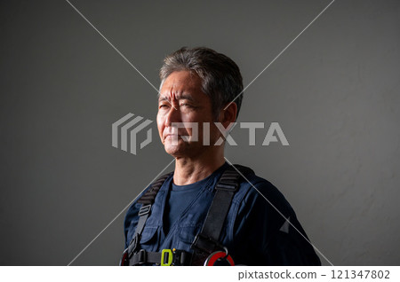 A stubborn-looking man wearing a full harness 121347802