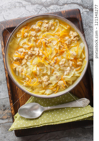 Egg roll cabbage soup with ground pork and vegetables closeup on the baking dish. Vertical top view Egg roll cabbage soup with ground pork and vegetables closeup on the baking dish. Vertical top view 121348277