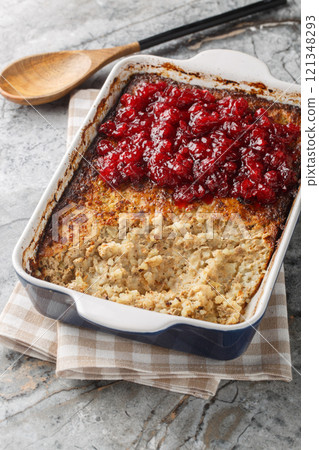 Finnish casserole Maksalaatikko made of Rice and liver with Cranberry sauce closeup on the baking dish. Vertical Finnish casserole Maksalaatikko made of Rice and liver with Cranberry sauce closeup on the baking dish. Vertical 121348293