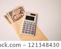 New 10,000 yen bill in an envelope and a calculator - stock photo 121348430
