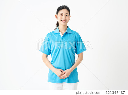 Portrait of a young woman working in the nursing care industry wearing a light blue polo shirt Portrait of a young woman working in the nursing care industry wearing a light blue polo shirt 121348487