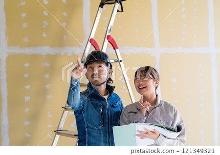 Men and women in work clothes looking at drawings and having a meeting 121349321