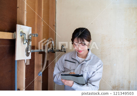 穿著工作服檢查的日本婦女 穿著工作服檢查的日本婦女 121349503