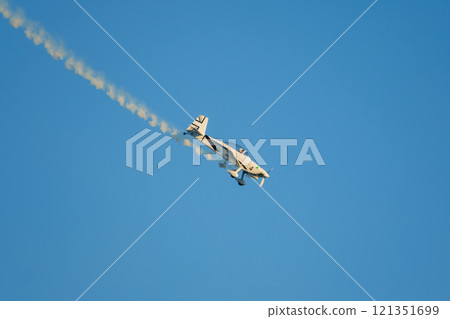 Stunt aerobatic plane performing stunts in air 121351699