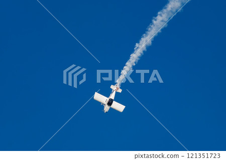 Stunt aerobatic plane performing stunts in air Stunt aerobatic plane performing stunts in air 121351723