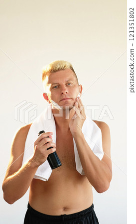 Shaving man. Facial grooming. Confident shirtless blond guy applying skin foam on face isolated on white empty space background. Shaving man. Facial grooming. Confident shirtless blond guy applying skin foam on face isolated on white empty space background. 121351802