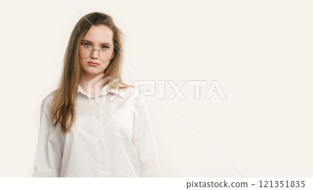 Serious teenager portrait. Lady offended. Strict disappointed girl in white posing isolated on light copy space background. Serious teenager portrait. Lady offended. Strict disappointed girl in white posing isolated on light copy space background. 121351835