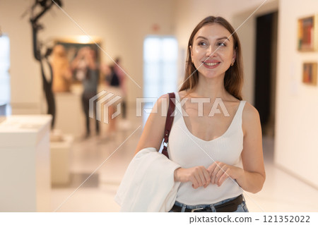 Woman studying exhibits in a museum 121352022