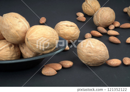 Almonds and walnuts in matte black background Almonds and walnuts in matte black background 121352122