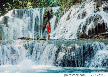 Beauty woman in red swimsuit staying on scenic cascade waterfalls in Central Sulawesi 121352452