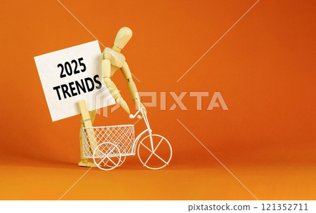 Planning 2025 trends new year symbol. Concept words 2025 Trends on beautiful white paper on wooden clothespin. Bicycle. Beautiful orange background. Business 2025 trends new year concept. Copy space. 121352711