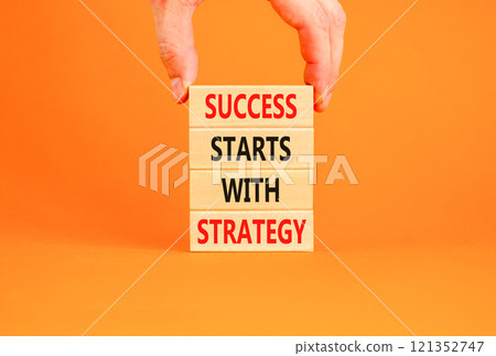 Success starts with strategy symbol. Concept words Success starts with strategy on beautiful wooden blocks. Beautiful orange background. Business and success starts with strategy concept. Copy space. Success starts with strategy symbol. Concept words Success starts with strategy on beautiful wooden blocks. Beautiful orange background. Business and success starts with strategy concept. Copy space. 121352747