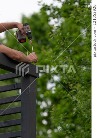 The craftsman screws into the wooden beam to connect the wall to the upper beam. 121352926