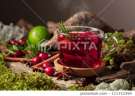 Hot winter drink with cranberries, lime, and rosemary on a old wooden board. Hot winter drink with cranberries, lime, and rosemary on a old wooden board. 121352994