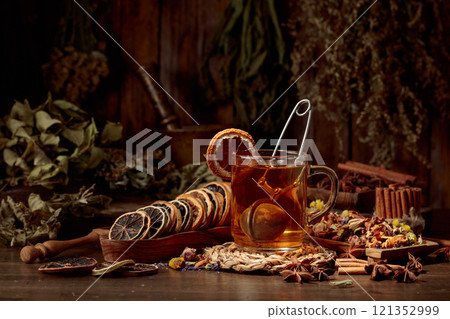 Cup of herbal tea with various dried herbs, flowers, and spices. 121352999