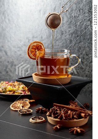 Cup of herbal tea with ingredients and slices of dried orange slices. Cup of herbal tea with ingredients and slices of dried orange slices. 121353002