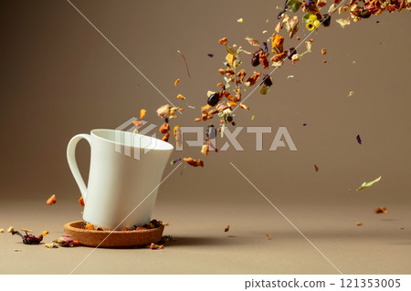 Ingredients for making herbal tea are poured into a white mug. 121353005