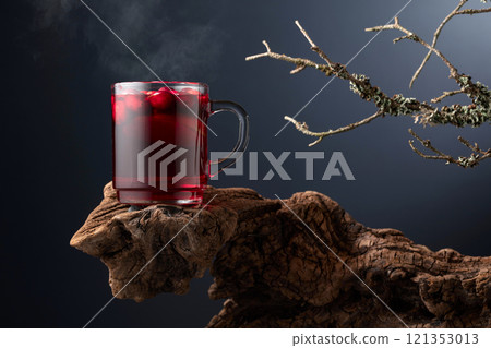 Hot drink with cranberries and lime on a old wooden snag. 121353013