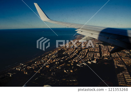 Airplane Wing View Over a Vibrant Coastal City Rome 121353268