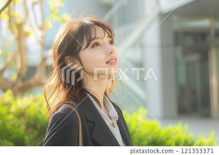 A new graduate woman in a suit surrounded by natural light 121353371