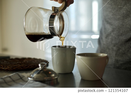 Pouring drip coffee into a cup 121354107