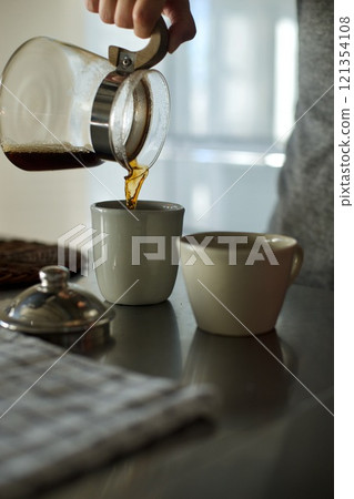 將滴漏式咖啡倒入杯中 將滴漏式咖啡倒入杯中 121354108