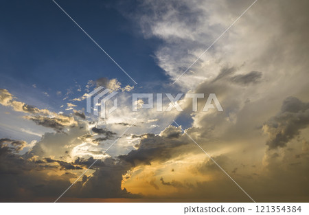 Dramatic sunset sky covered with colorful yellow clouds. Panoramic skyscape 121354384