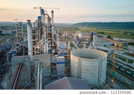 Cement plant with high factory structure and tower cranes at industrial production area. Manufacture, global industry and air pollution concept Cement plant with high factory structure and tower cranes at industrial production area. Manufacture, global industry and air pollution concept 121354500