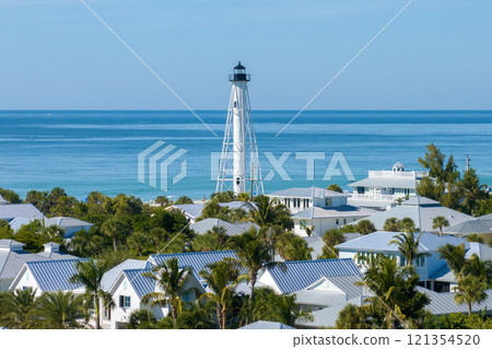 Boca Grande, Florida. Lighthouse on ocean shore for commercial vessels navigation. Expensive waterfront houses between green palm trees on Gasparilla Island Boca Grande, Florida. Lighthouse on ocean shore for commercial vessels navigation. Expensive waterfront houses between green palm trees on Gasparilla Island 121354520