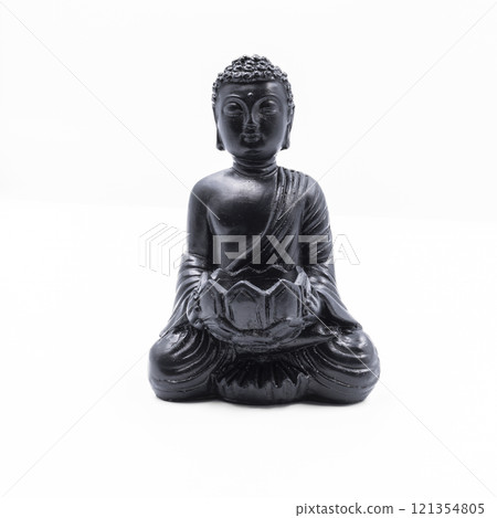 A serene black Buddha statue sitting in a meditative pose on a lotus flower. The minimalist design and smooth finish create a calming and peaceful atmosphere. 121354805
