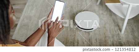 Website banner with unrecognizable woman controlling robot vacuum cleaner with app Website banner with unrecognizable woman controlling robot vacuum cleaner with app 121354812