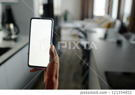 Medium close up of unrecognizable female hand holding smartphone with white screen in blue case Medium close up of unrecognizable female hand holding smartphone with white screen in blue case 121354922
