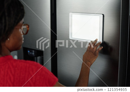 High angle shot of unrecognizable housewife installing app for smart home to control refrigerator High angle shot of unrecognizable housewife installing app for smart home to control refrigerator 121354935