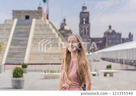 Woman tourist exploring the historic Zocalo square in Mexico City, standing in front of a replica Aztec pyramid with the Mexican flag waving in the background. The Metropolitan Cathedral can be seen Woman tourist exploring the historic Zocalo square in Mexico City, standing in front of a replica Aztec pyramid with the Mexican flag waving in the background. The Metropolitan Cathedral can be seen 121355549