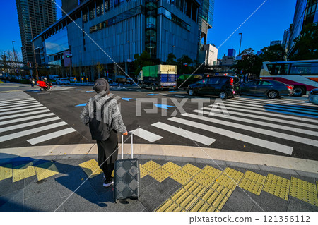 Back view of a female traveler waiting for a traffic light 121356112