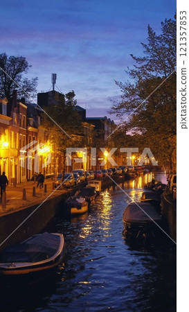 Canal with boats and houses illuminated in the evening. Haarlem, Netherlands 121357853