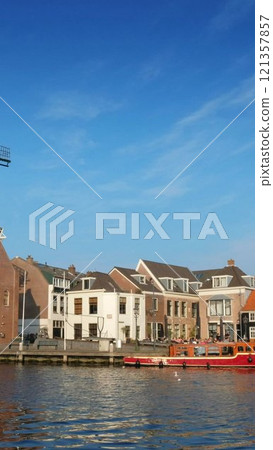 View of Harlem landmark windmill De Adriaan on Spaarne river. Harlem, Netherlands 121357857