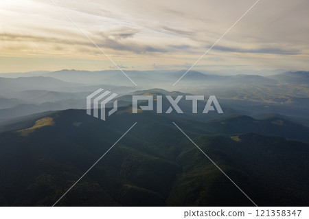 Beautiful mountain panoramic landscape with hazy peaks and foggy valley at sunset 121358347