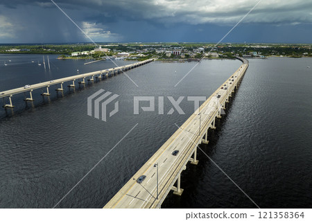 Barron Collier Bridge and Gilchrist Bridge in Florida with moving traffic. Transportation infrastructure in Charlotte County connecting Punta Gorda and Port Charlotte over Peace River 121358364