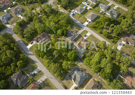 Aerial view of suburban landscape with private homes between green palm trees in Florida quiet residential area Aerial view of suburban landscape with private homes between green palm trees in Florida quiet residential area 121358483