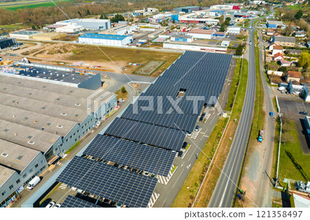 Aerial view of solar panels installed over parking lot with parked cars for effective generation of clean energy 121358497