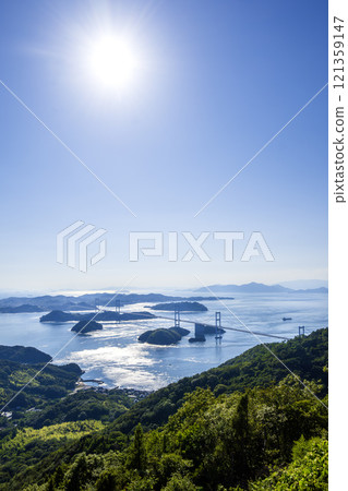 Shimanami Kaido: Kurushima-Kaikyo Bridge and the beautiful islands seen from Kirosan Observation Park. Afternoon light. Vertical composition. Photographed with a Nikon Z50. Shimanami Kaido: Kurushima-Kaikyo Bridge and the beautiful islands seen from Kirosan Observation Park. Afternoon light. Vertical composition. Photographed with a Nikon Z50. 121359147