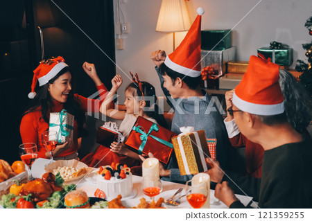 Happy family with gifts celebrating Christmas together Happy family with gifts celebrating Christmas together 121359255